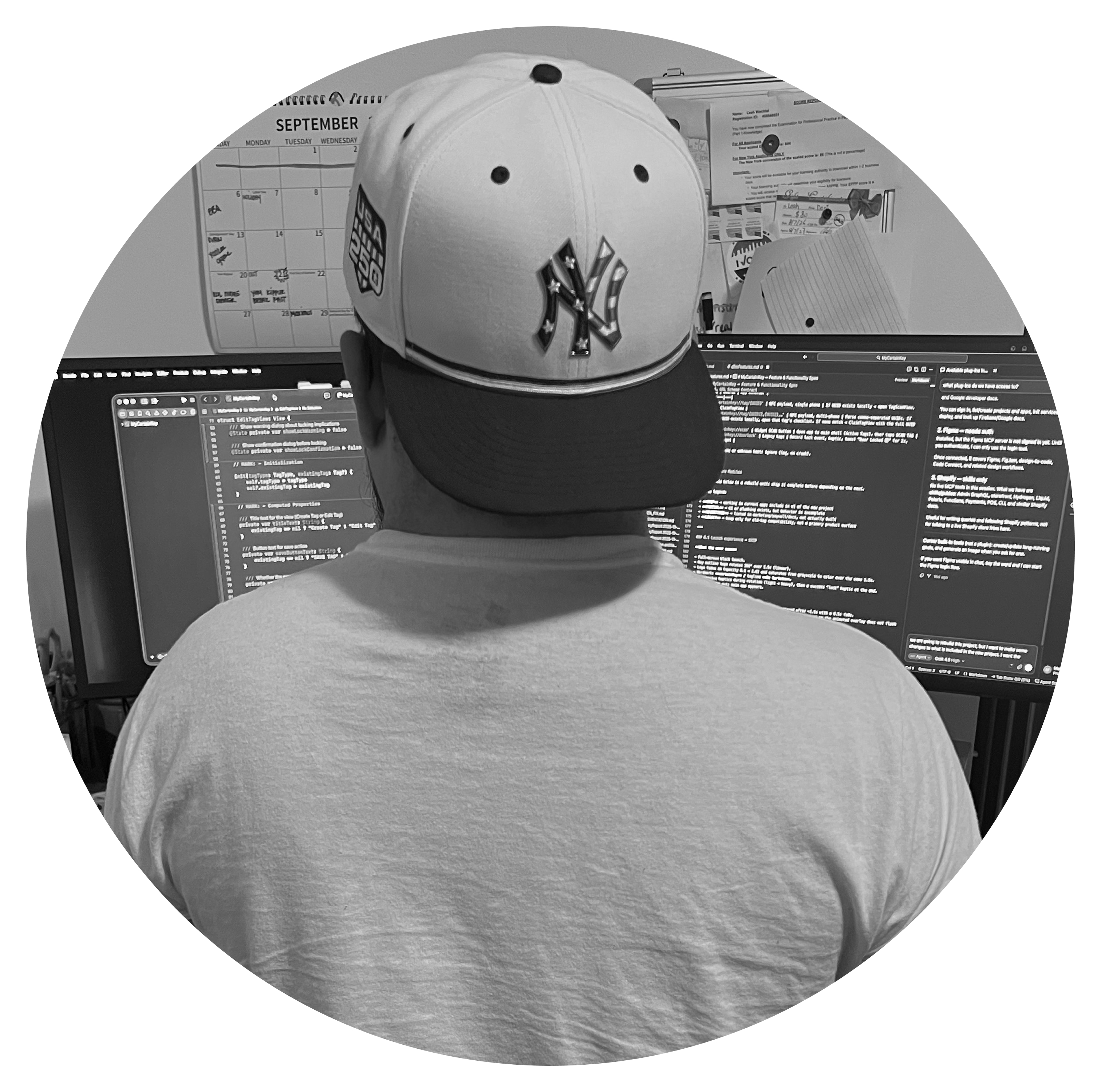 Marty at his desk, seen from behind in a New York Yankees cap, working across two monitors of code